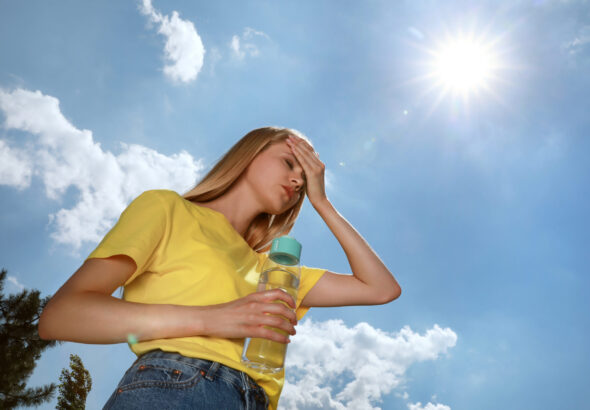 Woman,With,Bottle,Of,Water,Suffering,From,Heat,Stroke,Outdoors